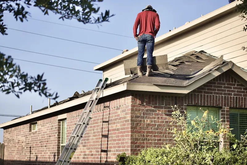 Professional roofer working on a residential roof in Moween
